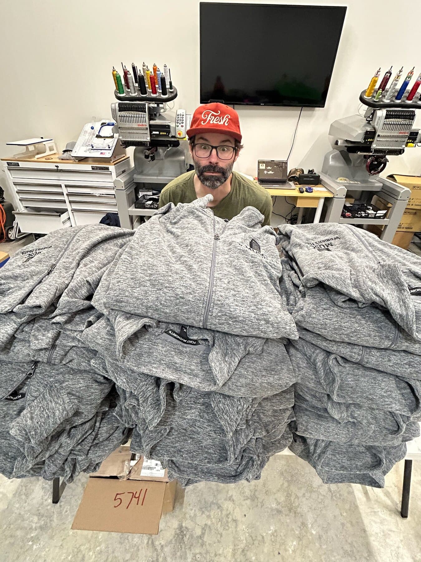 Fresh Local Tees team member with finished embroidered apparel
